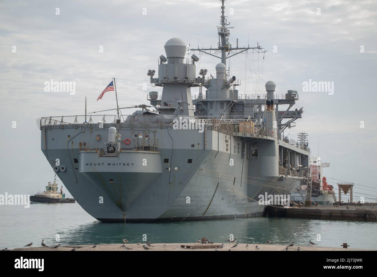 PORTO DI GIBUTI, Gibuti (26 aprile 2022) la nave di comando e controllo della classe Blue Ridge USS Mount Whitney (LCC 20) si trova nel porto, mentre un rimorchiatore Gibutiano si prepara alla partenza del monte Whitney. (STATI UNITI Foto Navy di Mass Communication Specialist 1st Classe Christopher Previc) Foto Stock