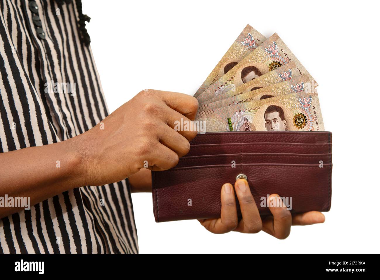 Female giusto mano che tiene la borsa marrone con le note di baht thailandesi, mano che rimuove i soldi dalla borsa isolato su bianco. Che rimuove i soldi dal portafoglio Foto Stock