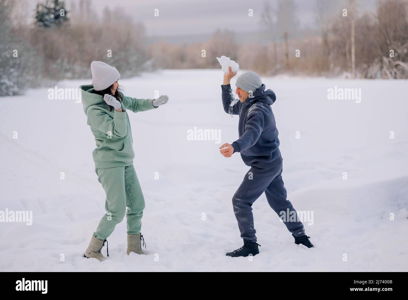 Coppia felice che gioca la partita invernale nella foresta all'aperto. Concetto di amore e piacere. Foto di alta qualità Foto Stock