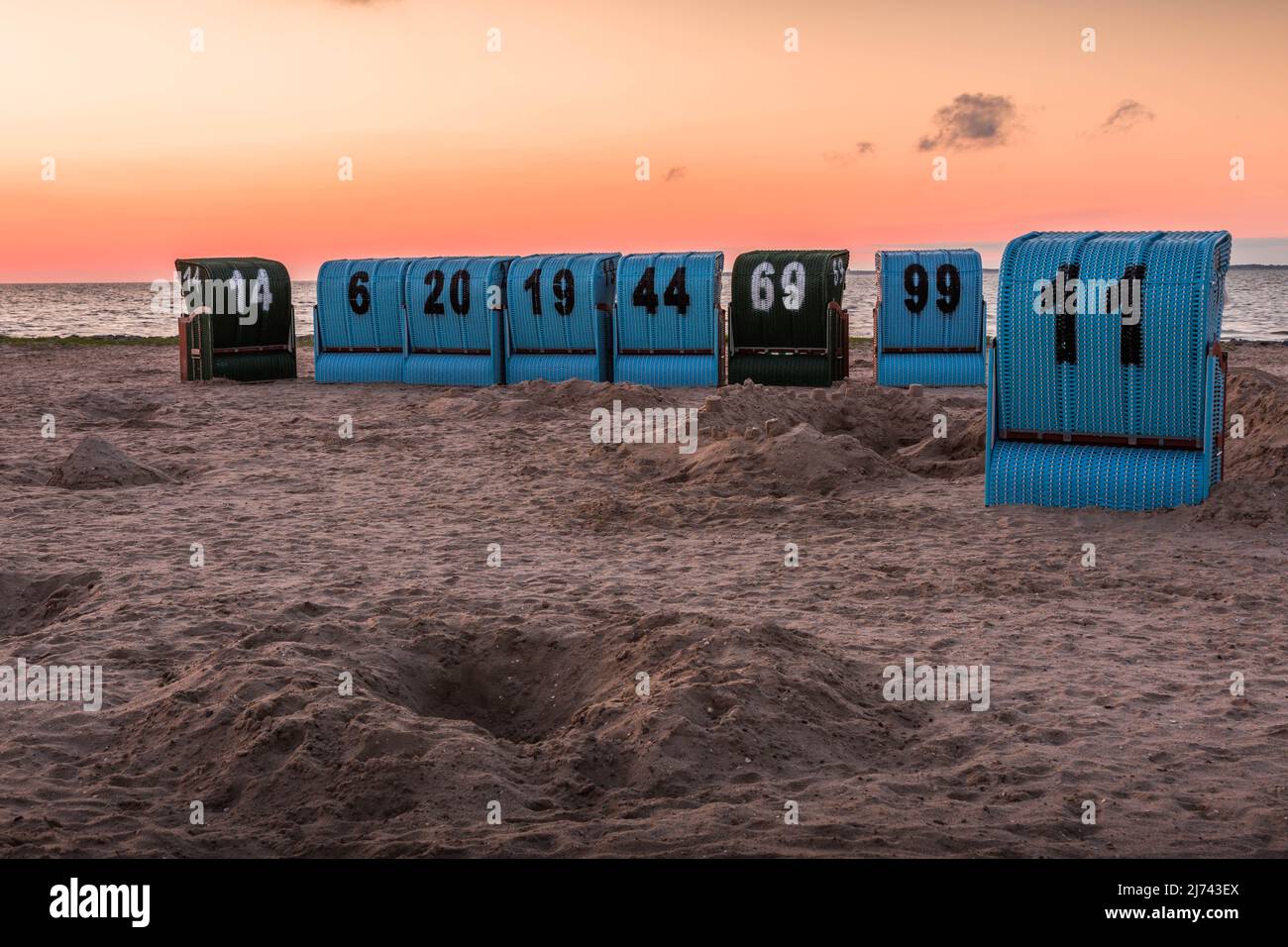 Sedie da spiaggia in vimini sulla spiaggia del Mare del Nord al tramonto, Neuharlingersiel, Frisia orientale, bassa Sassonia, Germania Foto Stock