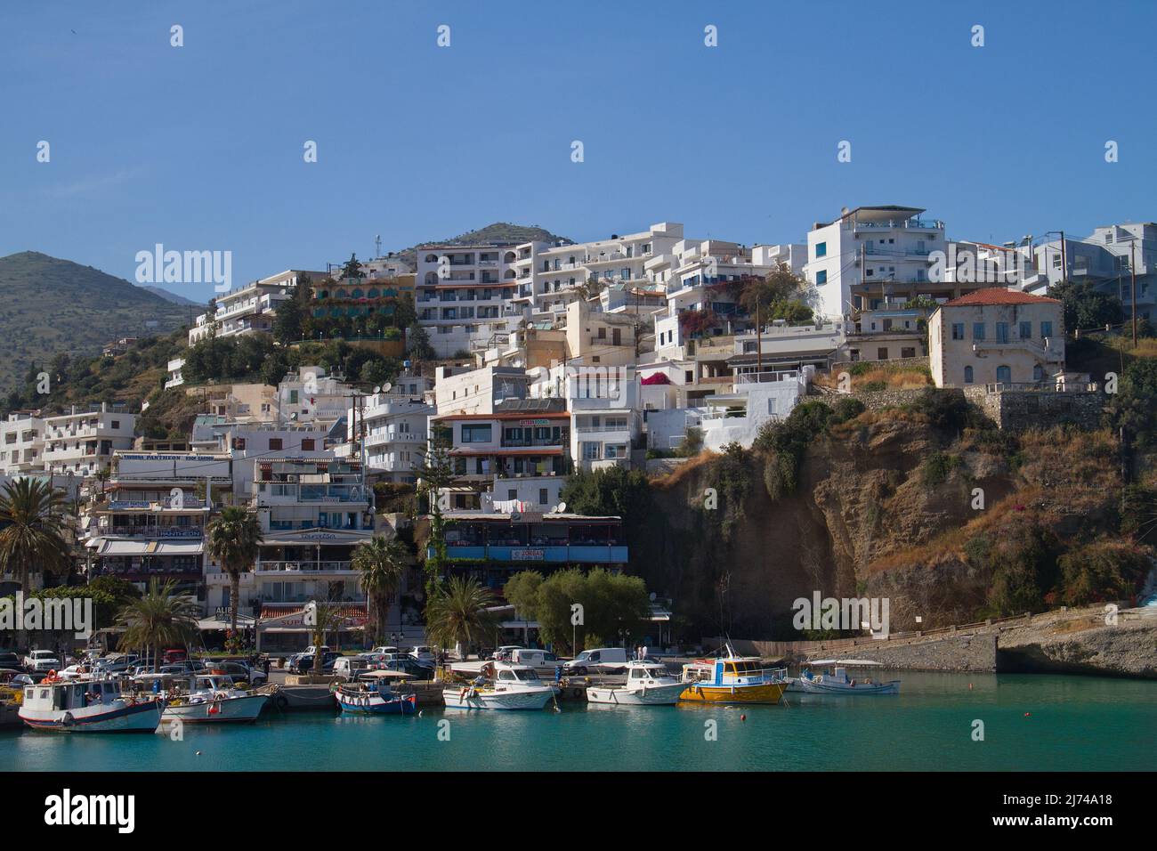 Agia Galini, pittoresco villaggio mediterraneo con case bianche e barche da pesca in porto con acqua blu Foto Stock