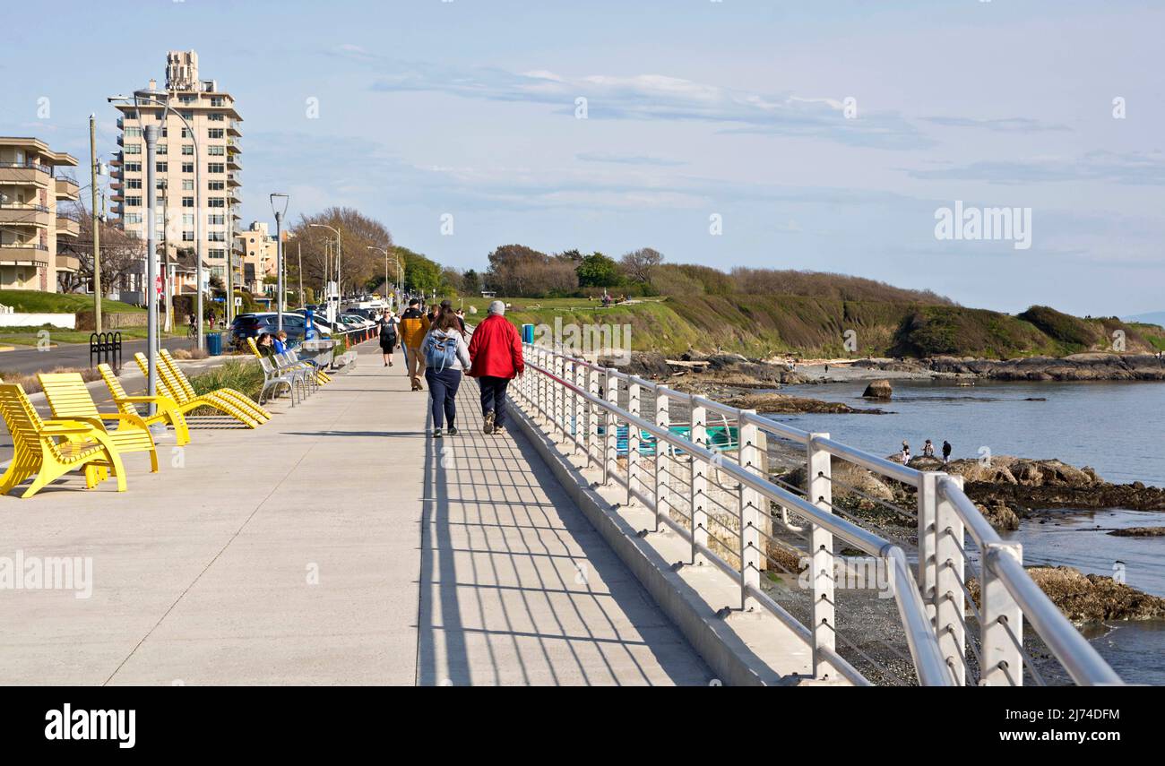 Persone che camminano lungo il muro di mare a Victoria, British Columbia, Canada, in primavera. Foto Stock