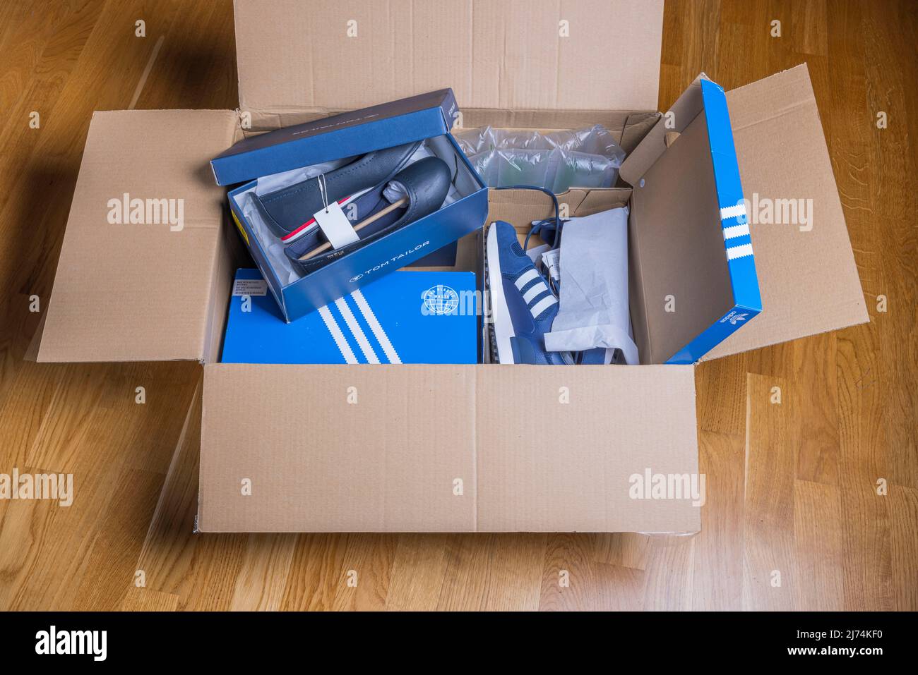 Vista ravvicinata della scatola di consegna a domicilio ricevuta con scarpe  Adidas e Tom Tailor. Svezia Foto stock - Alamy