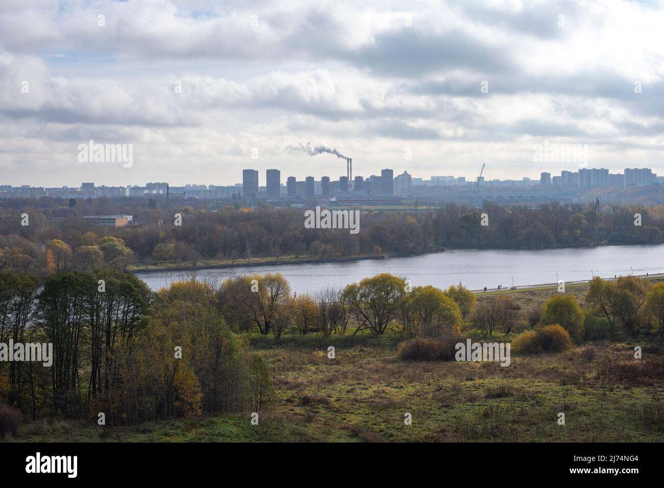 Nebbia autunno paesaggio Mosca Kolomenskoye parco. Un grattacielo e un camino fumante della città e un paesaggio idilliaco con un fiume nel foregroun Foto Stock