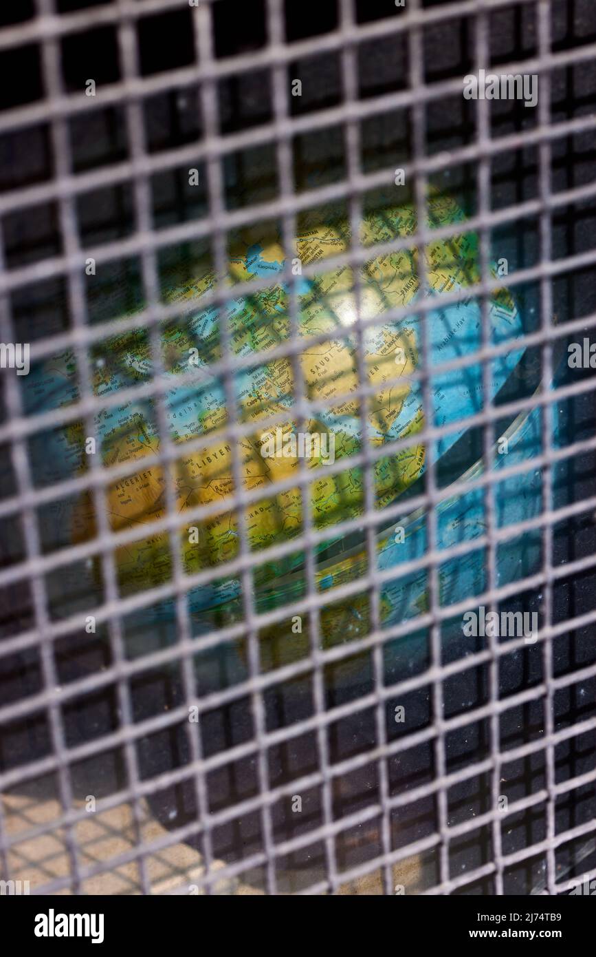 Globo separato dietro la griglia metallica Foto Stock