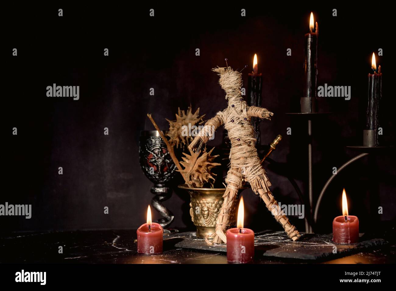 Bambola Voodoo, candele nere, pentagramma e vecchi libri sul tavolo delle streghe. Concetto occulto, esoterico, divinazione e wicca. Mistico, voodoo e vintage Foto Stock