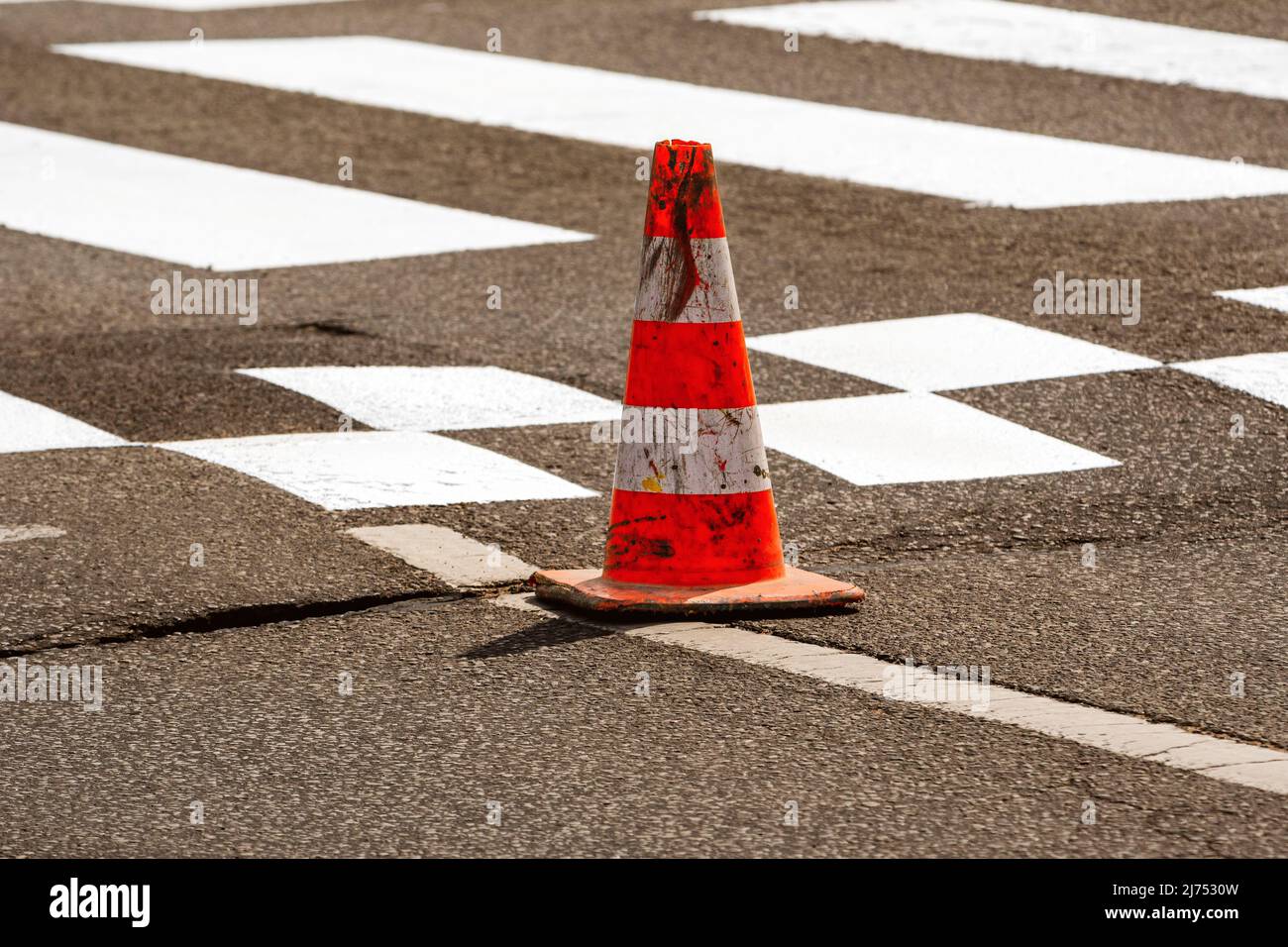 Lavoro su strada. Cono di costruzione. Cono di traffico, con bianco e strisce arancioni su asfalto. Street e i cartelli stradali per la segnalazione. Manutenzione stradale, und Foto Stock