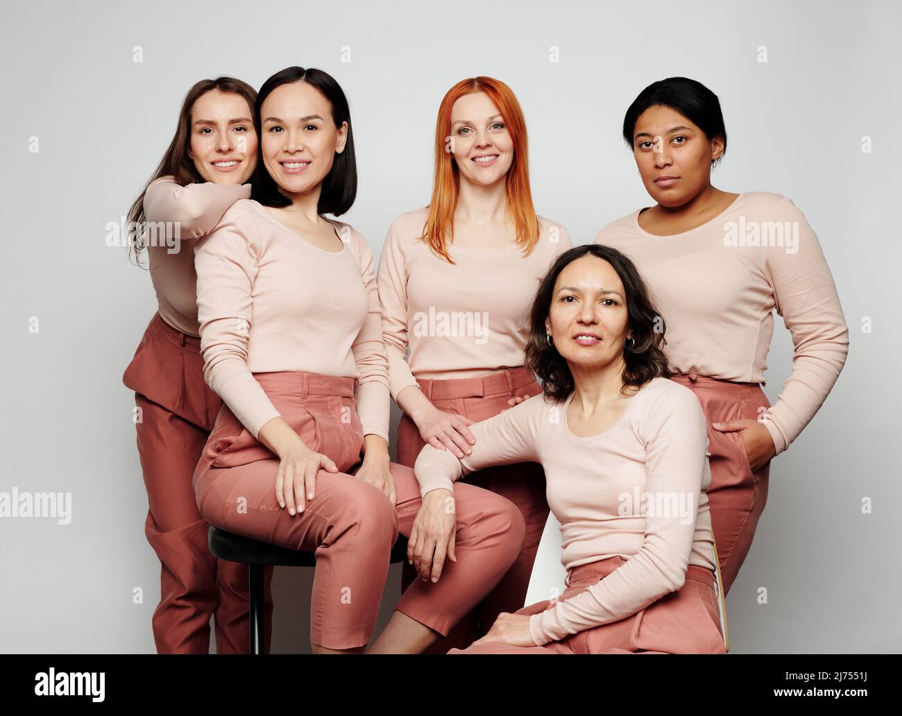 Gruppo di donne sorridenti uniche di razze e personaggi diversi in posa per poster pubblicitari Foto Stock