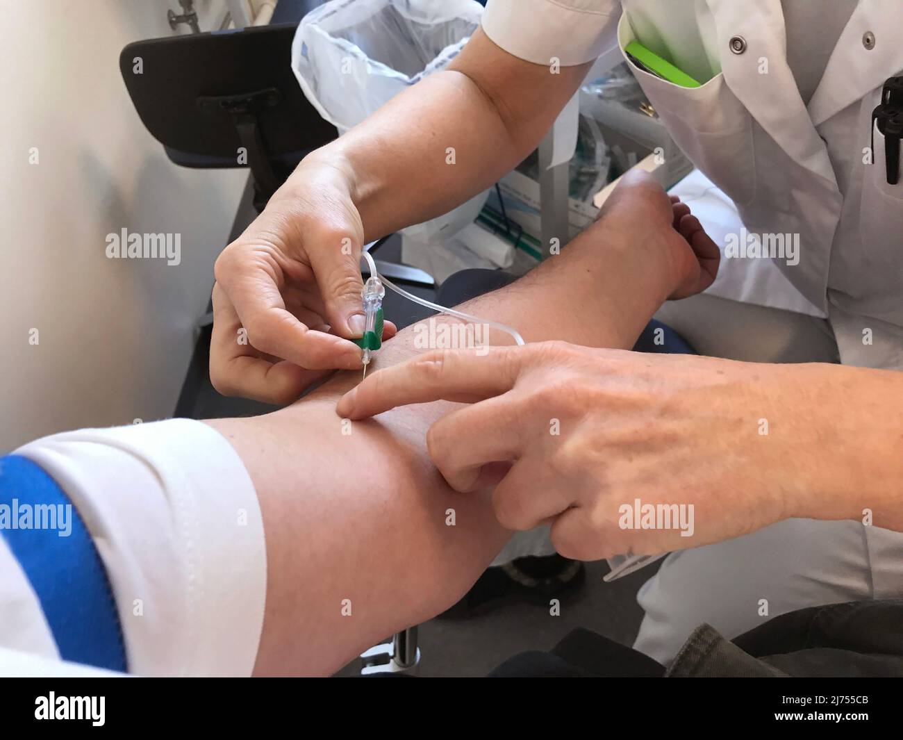 Il medico o l'infermiere usano la siringa con ago per prelevare il campione di sangue dal braccio del paziente con la siringa. Concetto di assistenza sanitaria. Immagine da vicino. Foto Stock