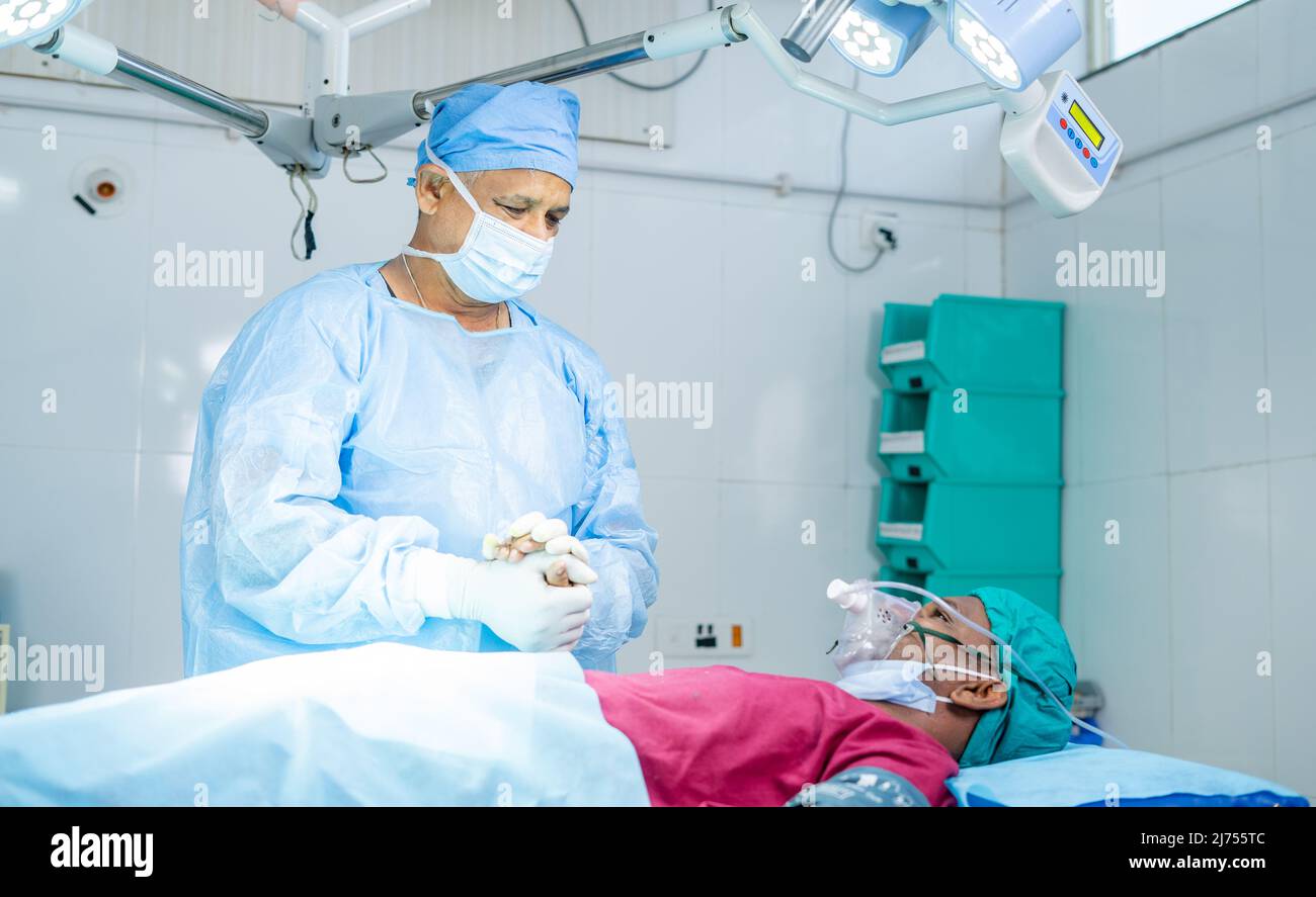 chirurgo in sala operatoria consolante il paziente prima dell'intervento chirurgico - concetto di fiducia, fiducioso buliding, empatia e trattamento sanitario Foto Stock