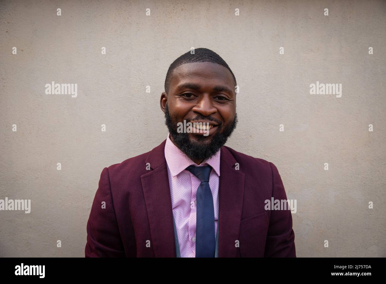 ritratto di un sorridente giovane imprenditore africano isolato su sfondo beige Foto Stock