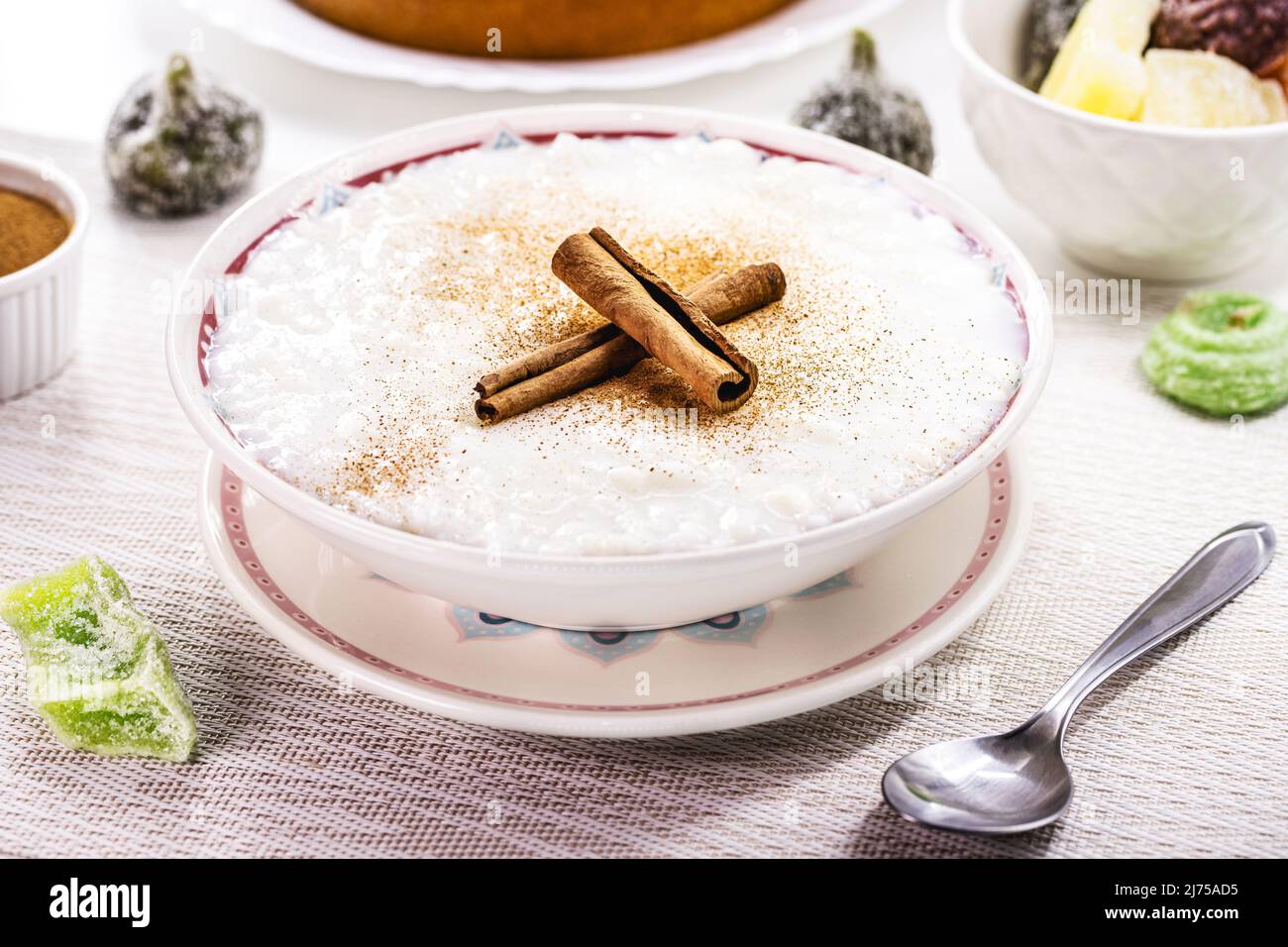 ciotola per budino di riso, budino fatto in casa a base di riso macinato, addolcito con polvere di cannella e corteccia di cannella. Dolci brasiliani rurali in background, Foto Stock