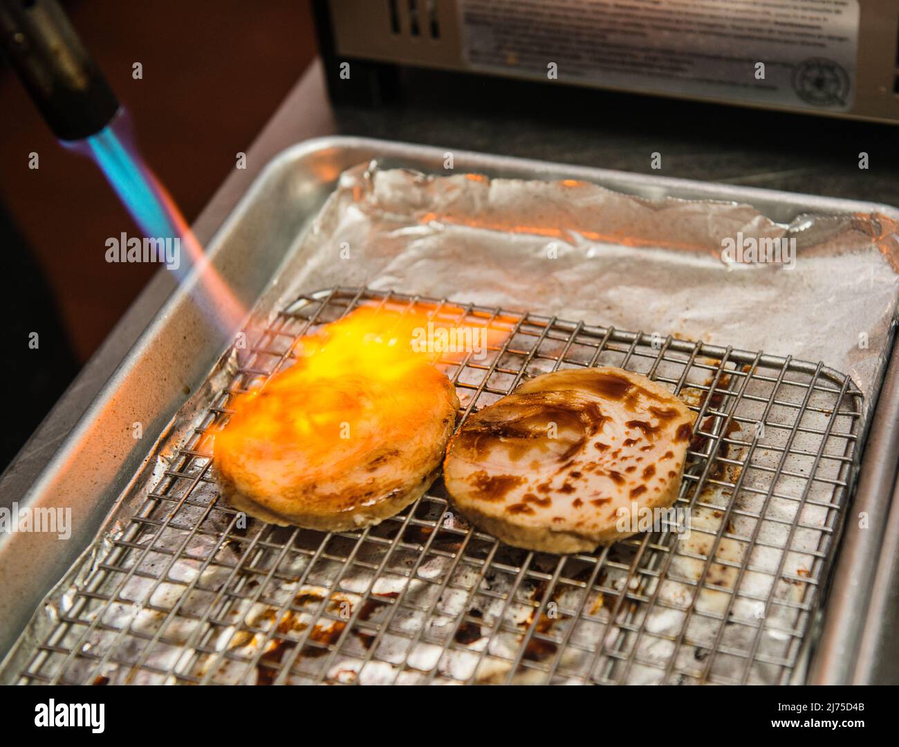 Carne di maiale con salsa di soia grigliata alla fiamma con un bruciatore a gas Foto Stock