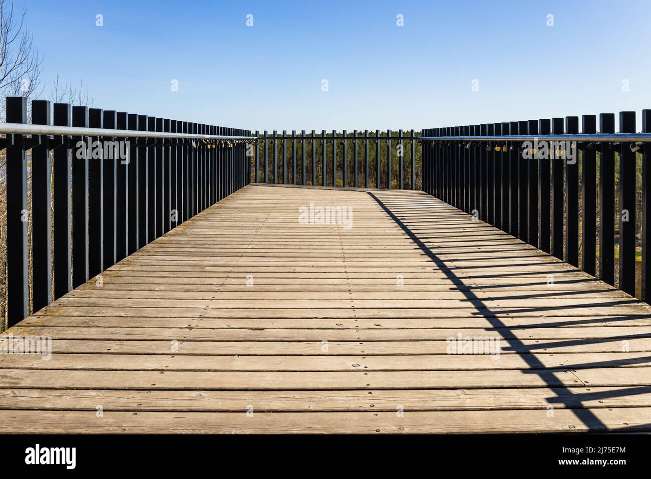 Piattaforma in legno con corrimano in acciaio e lucchetti d'amore appesi su di essa Foto Stock