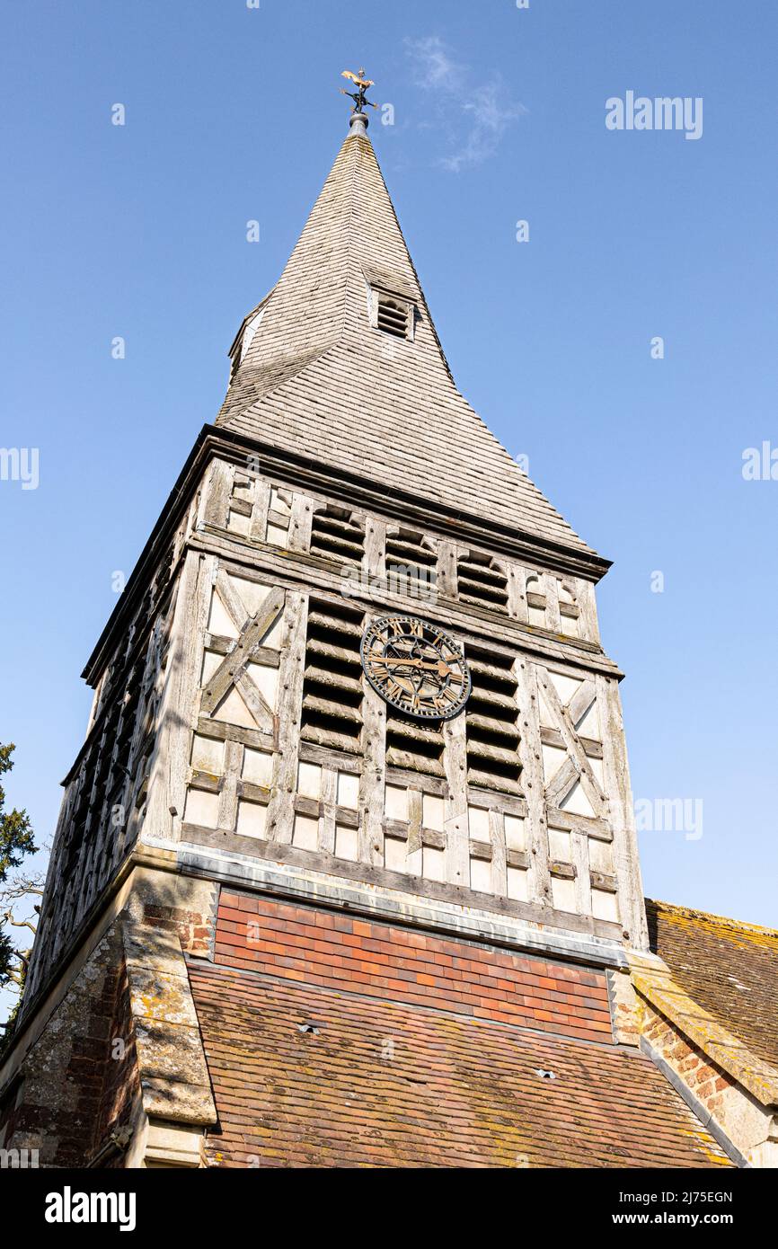 Guardando verso l'alto la guglia di ghiaia e la torre dell'orologio con struttura a legno della chiesa di St Marys, Bromsberrow, Gloucestershire, Inghilterra Regno Unito Foto Stock