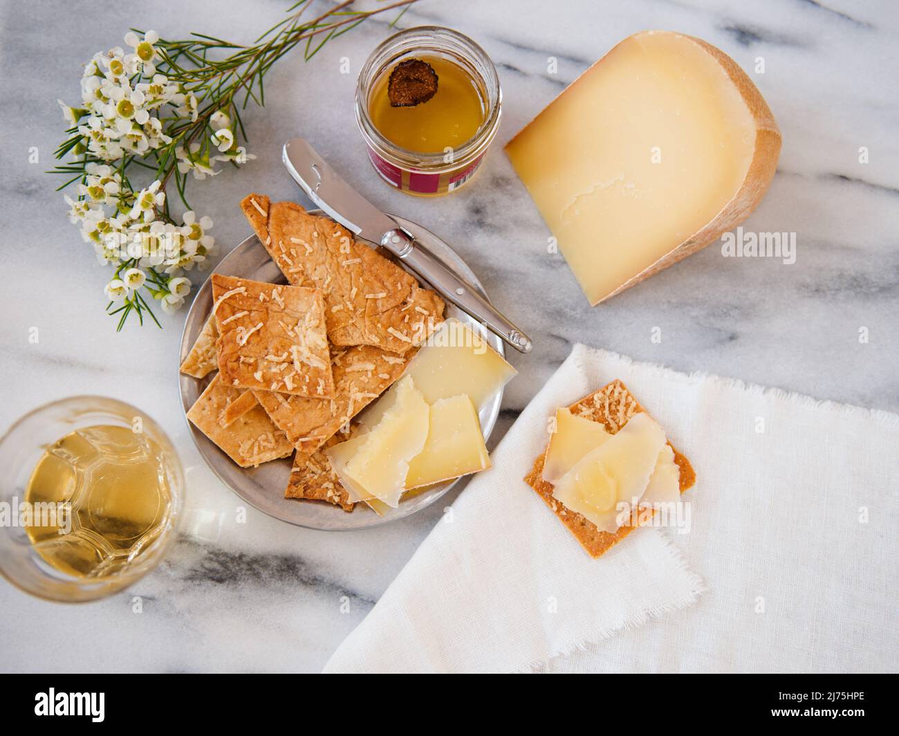 Formaggio gourmet con cracker, miele al tartufo e vino bianco Foto Stock