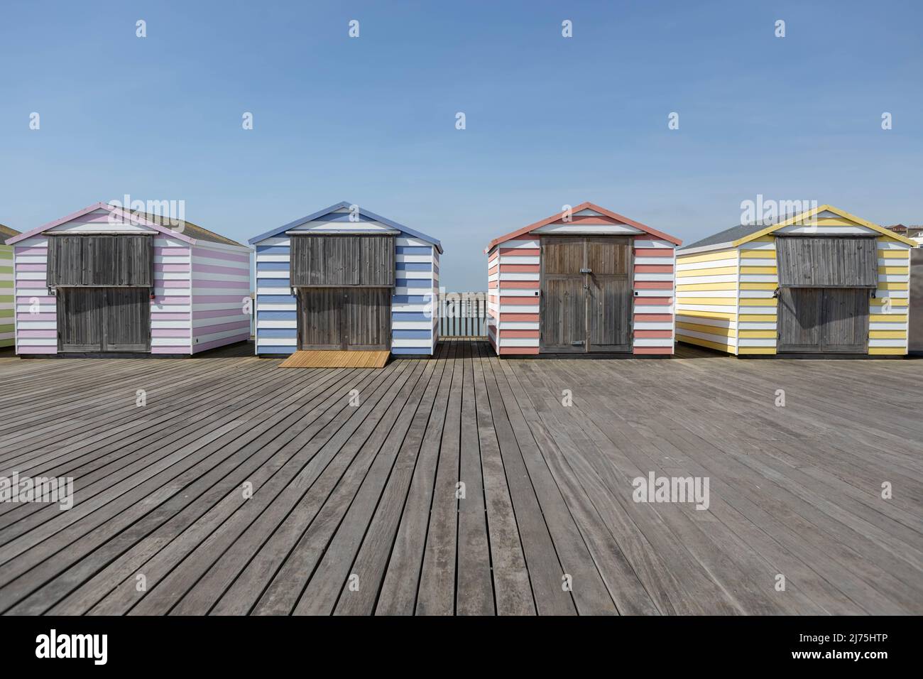 Capanne colorate sulla spiaggia su un molo Foto Stock