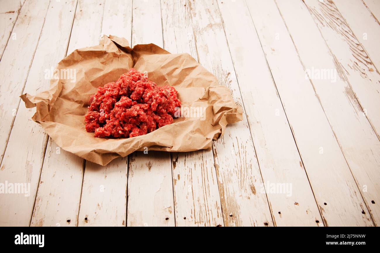 Carne macinata cruda in carta pergamena Foto Stock