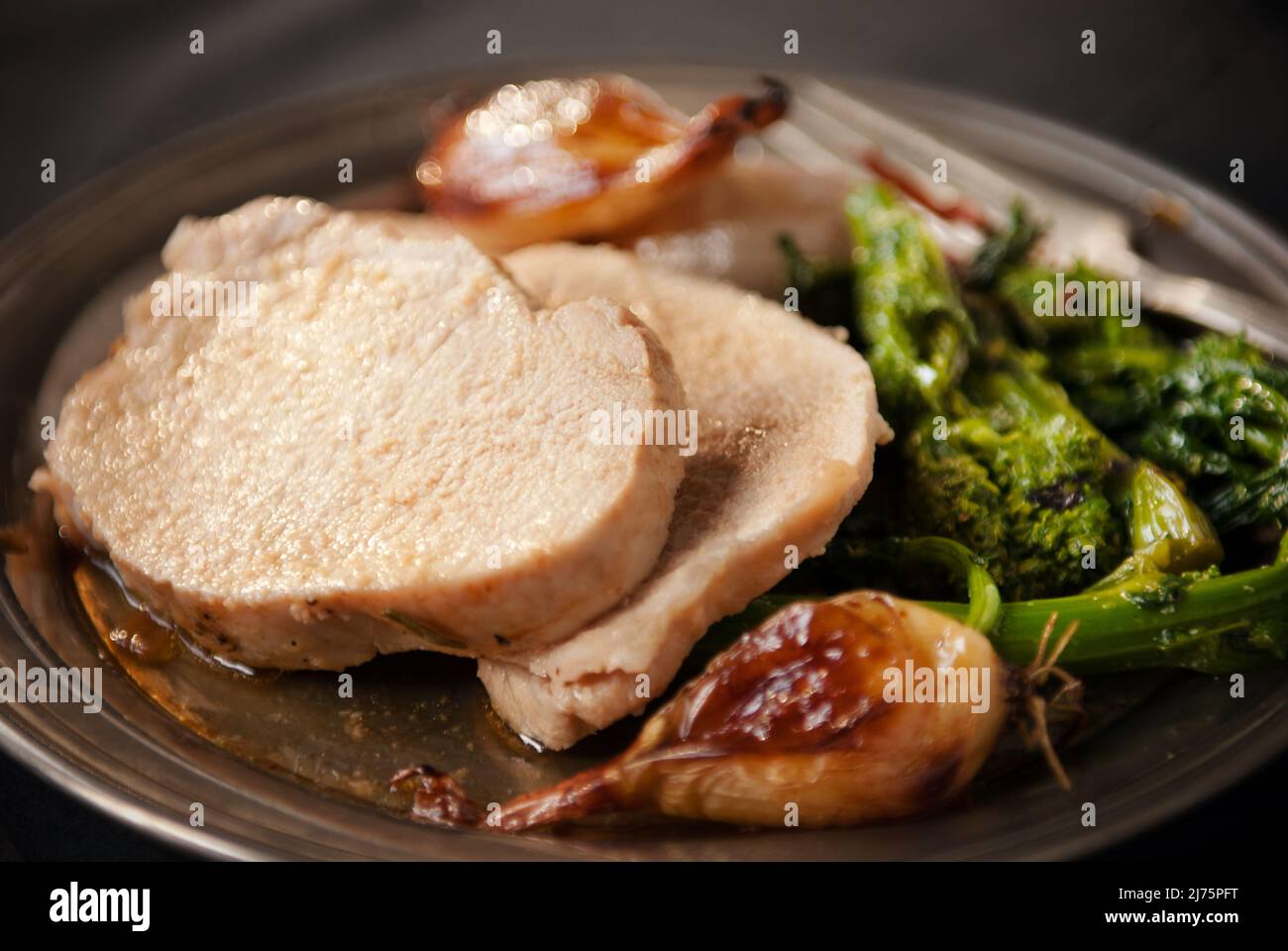 Arrosto di maiale con aglio e broccoli di rabbia Foto Stock