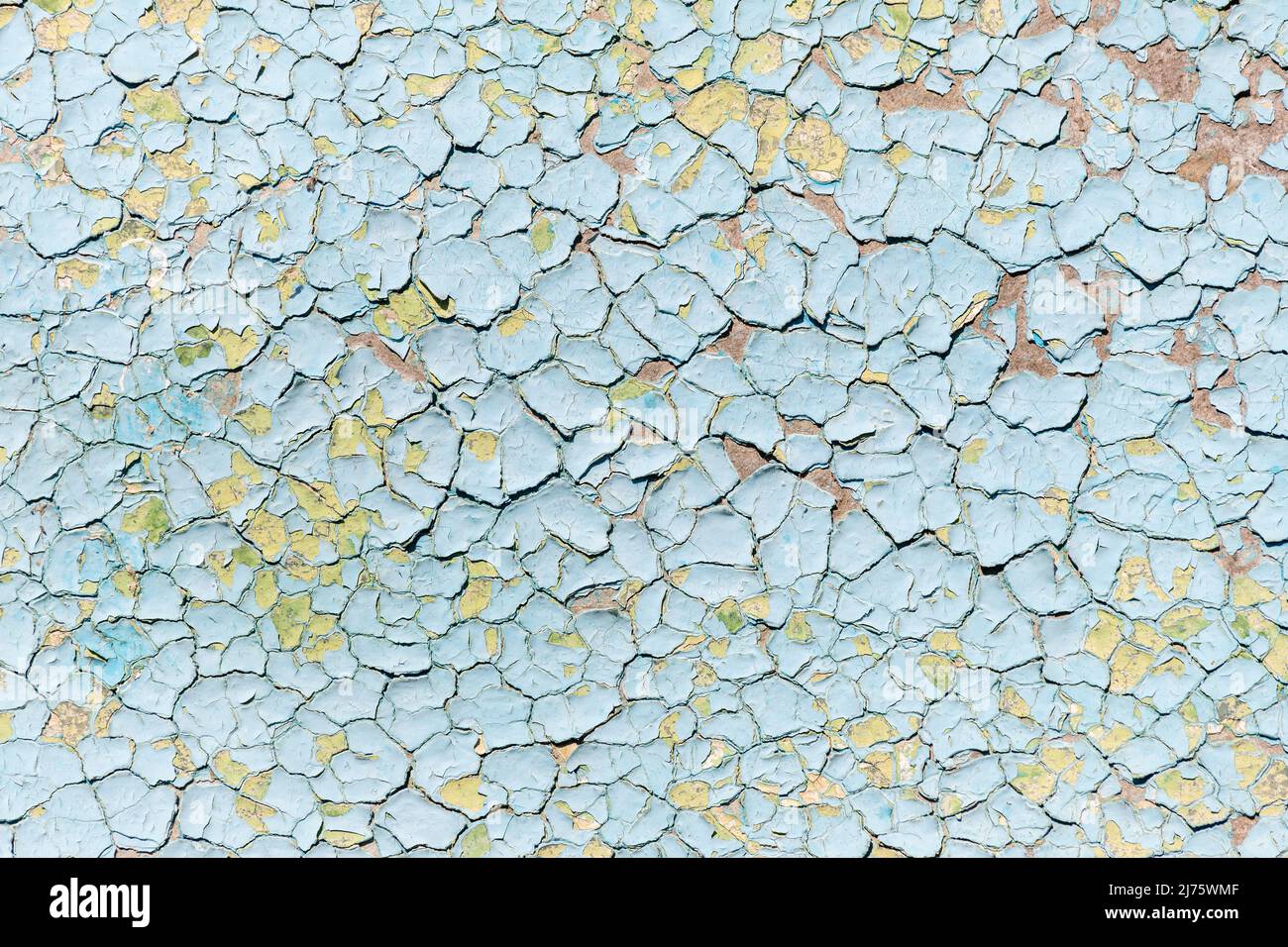 Superficie dipinta blu vecchia sbiadita e incrinata sulla parete interna esterna dell'edificio con strati di vernice graffiati invecchiati. Astratto stucco vecchio gesso Foto Stock