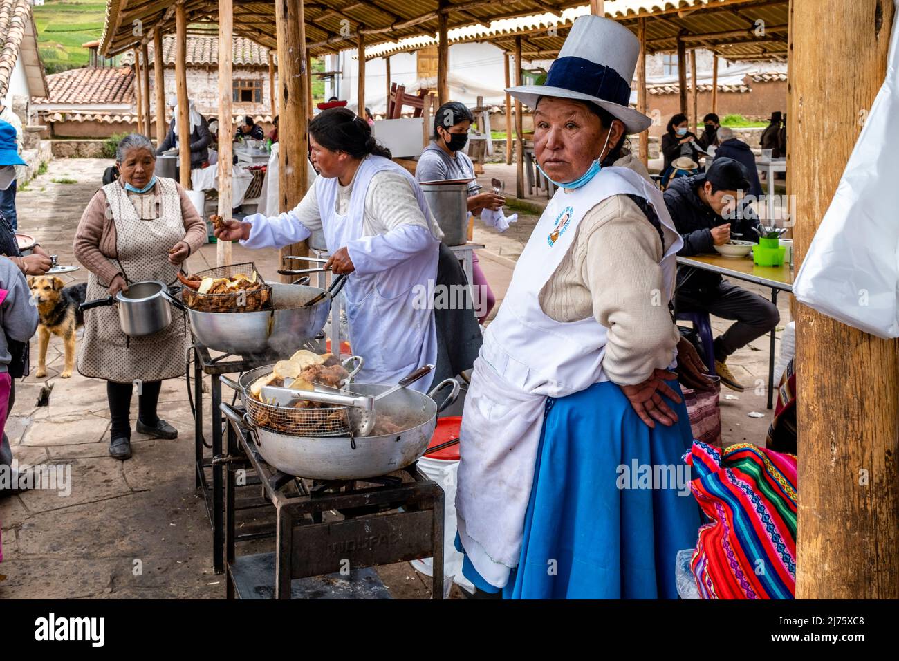 Le donne indigene Quechua cucinano cibo ad un caffè all'aperto al famoso mercato domenicale nel villaggio di Chinchero, nella regione di Cusco, in Perù. Foto Stock