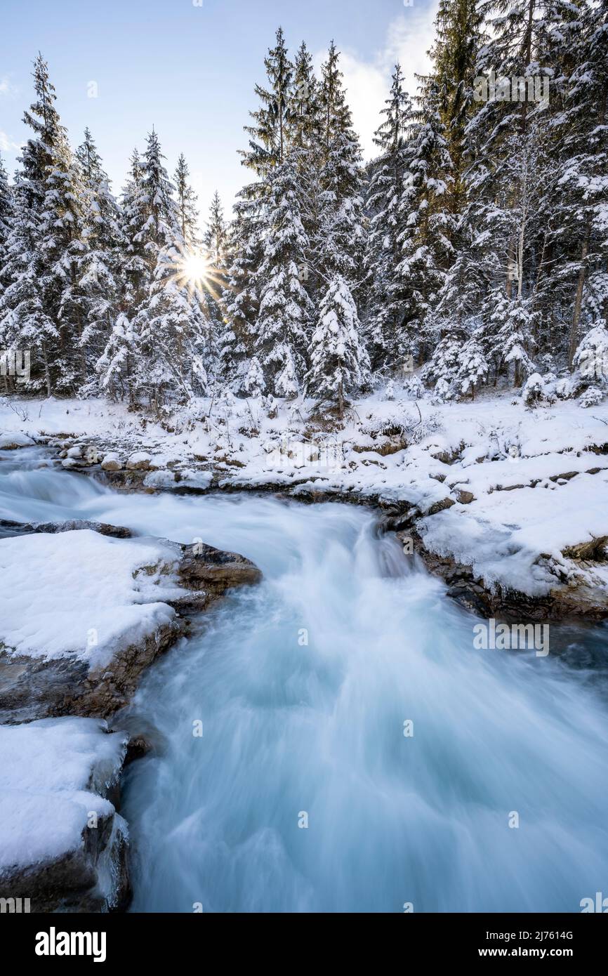 Sole con raggi del sole a Rissbach in Eng in Tirolo vicino Hinterriss in inverno con neve e ghiaccio Foto Stock