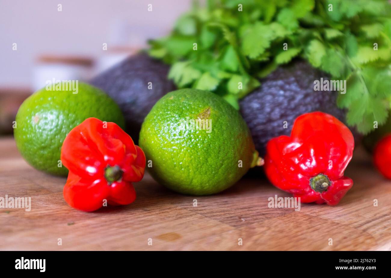 Peperoncino fresco di scotch Bonnet con coriandolo di lime e un avocado ingredienti per fare guacamole Foto Stock