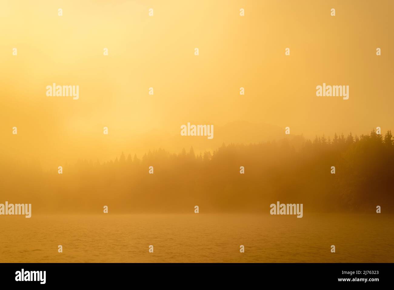 Il Geroldsee, anche Wagenbrüchsee in una mattinata di inizio autunno. La luce dell'alba colora tutto l'arancio dorato, sullo sfondo si vede l'ombra del Karwendel. Foto Stock