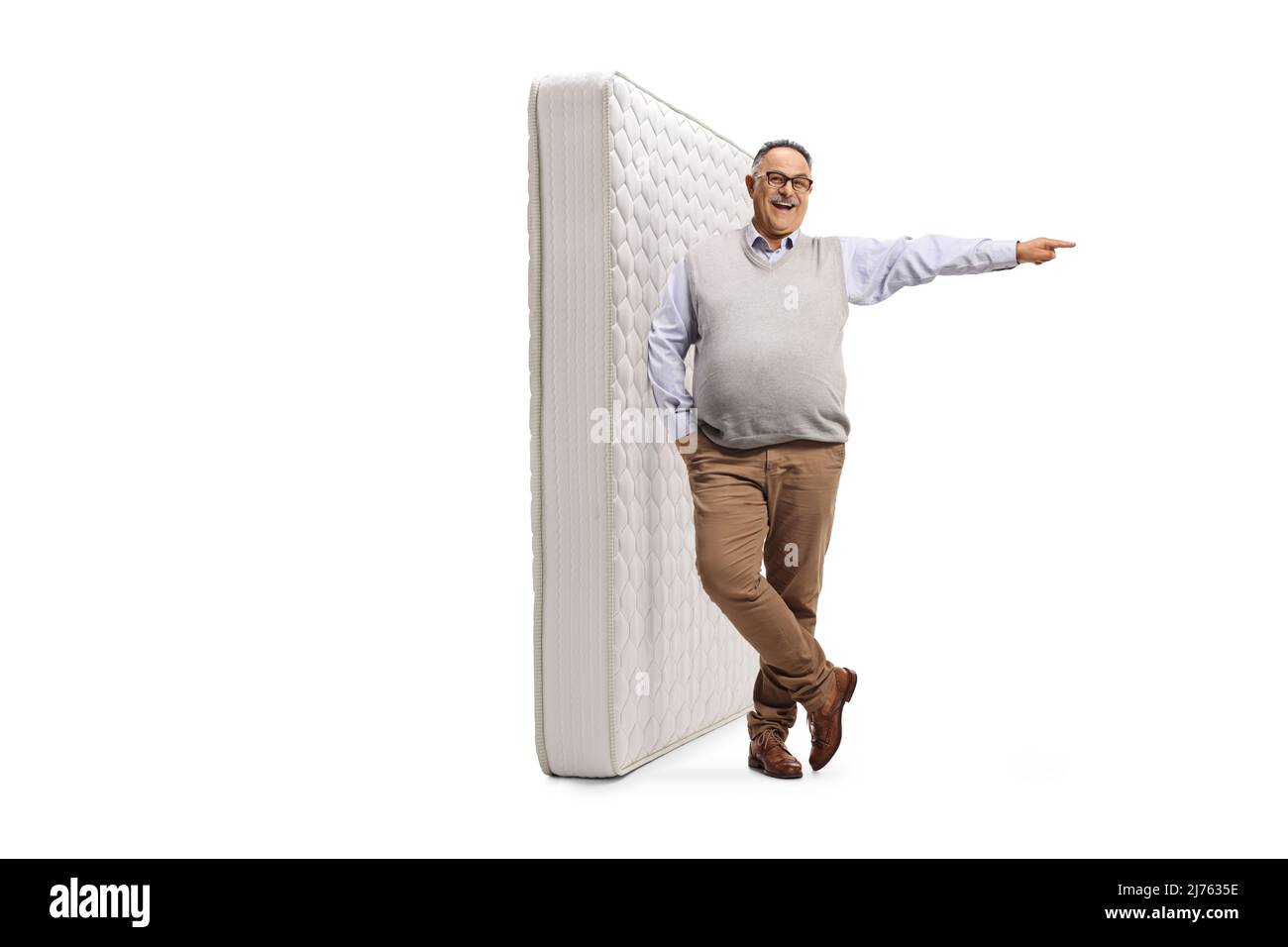 Ritratto a tutta lunghezza di un uomo maturo appoggiato su un materasso king size e rivolto verso il lato isolato su sfondo bianco Foto Stock