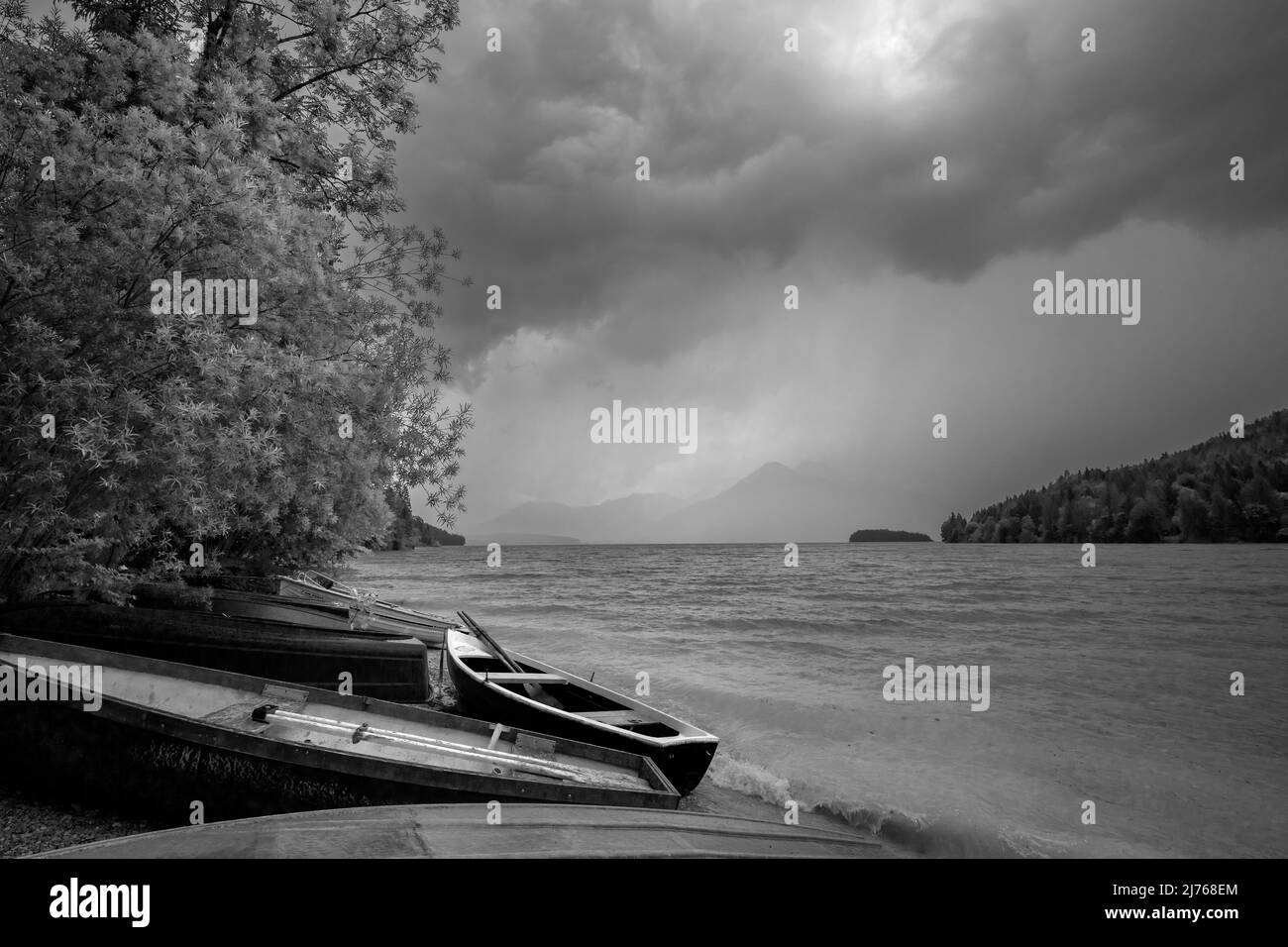 Tempesta all'ormeggio in barca a Niedernach sul lago Walchen. Sulla spiaggia si trovano diverse barche da pesca, sullo sfondo la piccola isola di Sassau e tra le nuvole il Herzogstand. Foto Stock