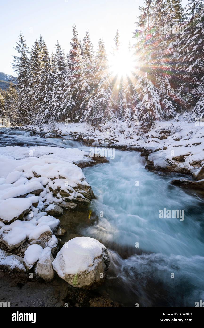 Sole con raggi del sole a Rissbach in Eng in Tirolo vicino Hinterriss in inverno con neve e ghiaccio Foto Stock