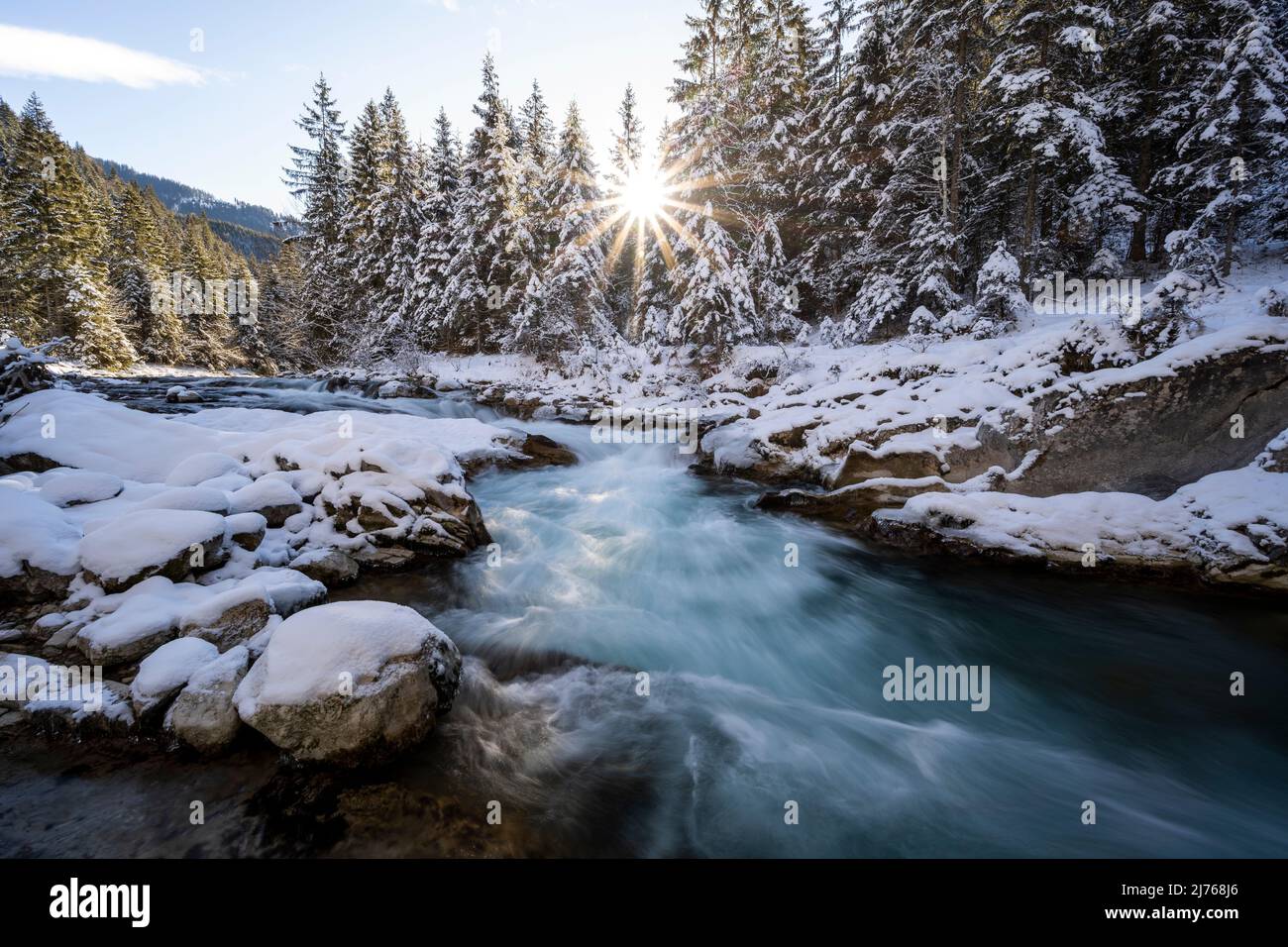 Sole con raggi del sole a Rissbach in Eng in Tirolo vicino Hinterriss in inverno con neve e ghiaccio Foto Stock
