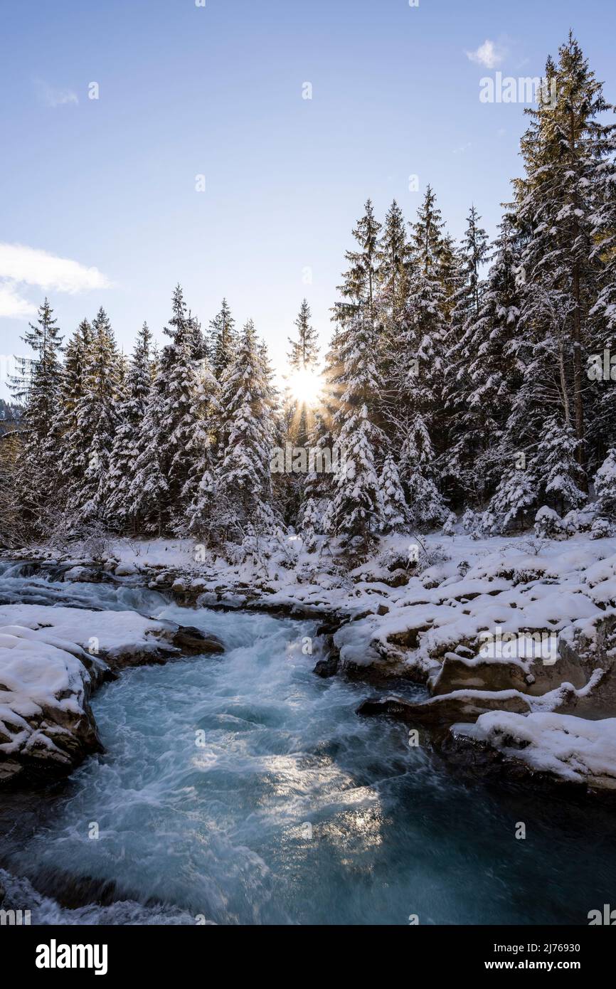 Sole con raggi del sole a Rissbach in Eng in Tirolo vicino Hinterriss in inverno con neve e ghiaccio Foto Stock