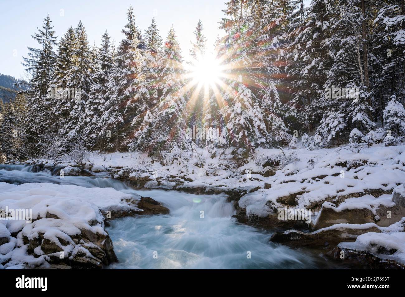 Sole con raggi del sole a Rissbach in Eng in Tirolo vicino Hinterriss in inverno con neve e ghiaccio Foto Stock