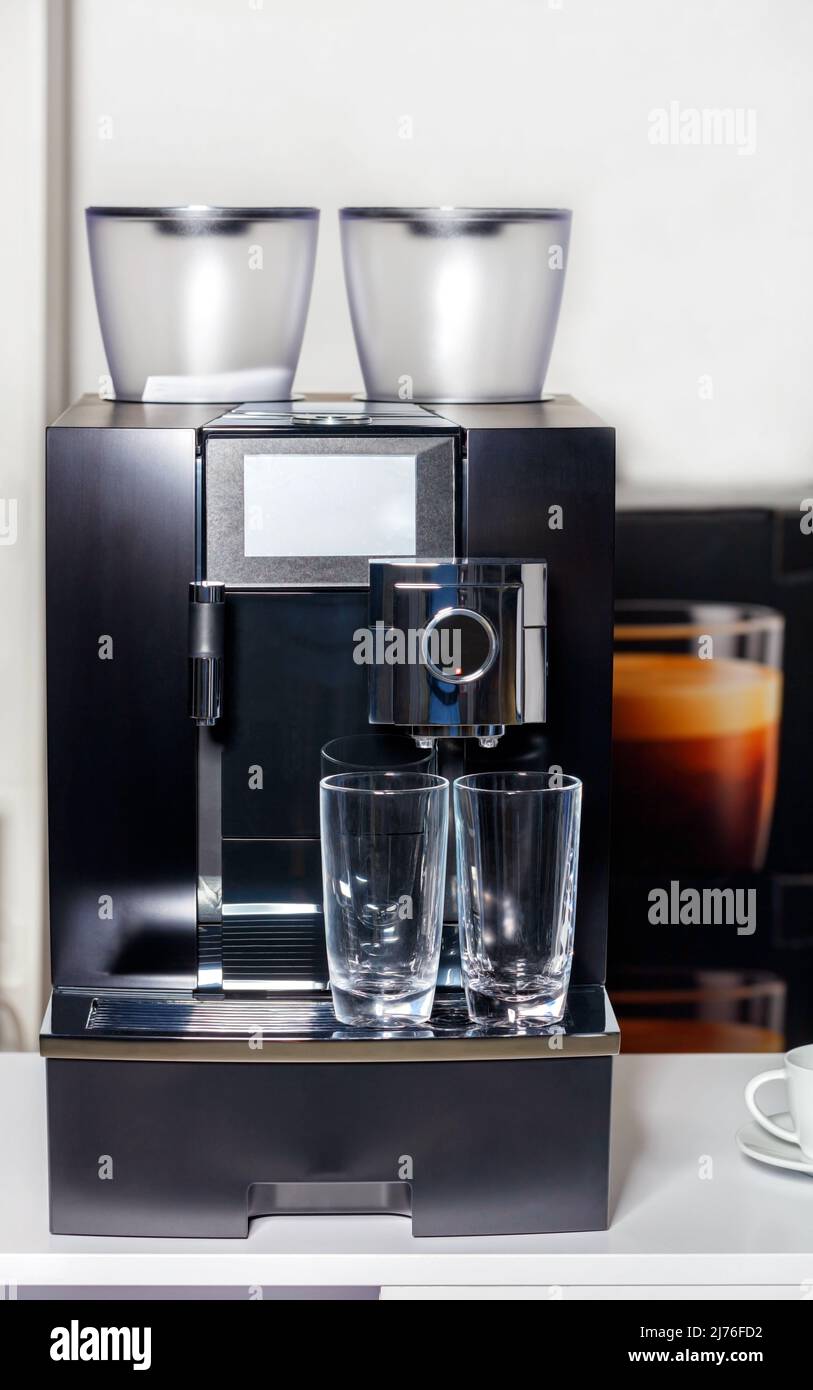 Due tazze di vetro vuote sono il caffè del supporto della macchina. Spazio di copia. Foto Stock