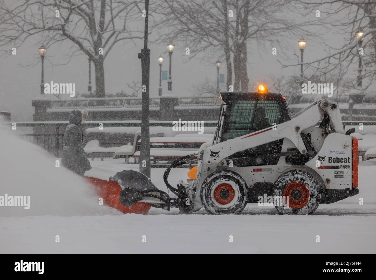 NEW YORK, N.Y. – 1 febbraio 2021: Un veicolo per la rimozione della neve passa un pedone a Lower Manhattan durante una tempesta invernale. Foto Stock