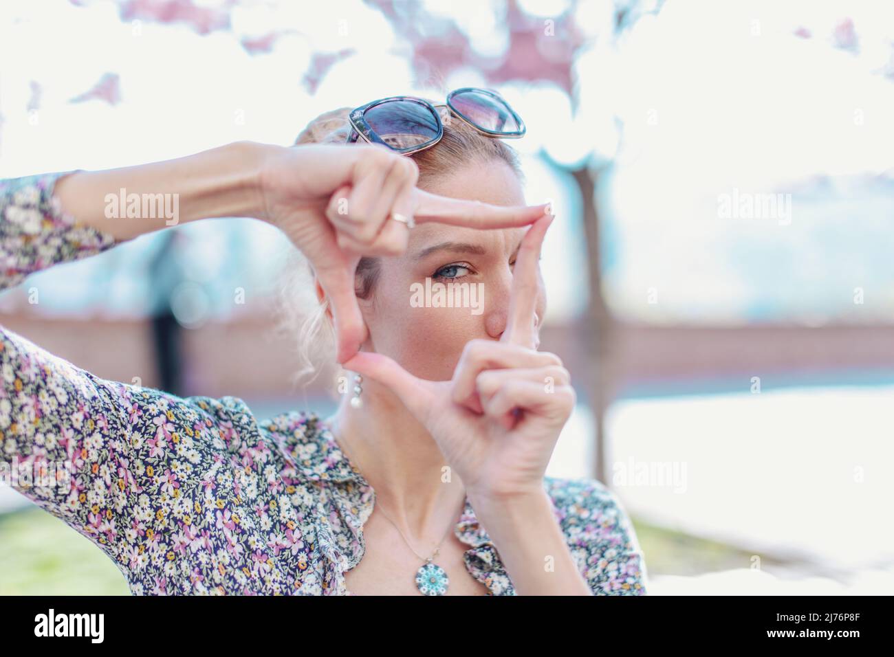 Giovane donna che forma cornice dalle dita, simbolo di fotografia Foto Stock