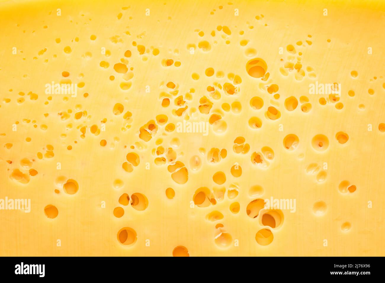 Struttura di formaggio con piccoli fori in primo piano. Sfondo alimentare. Foto Stock