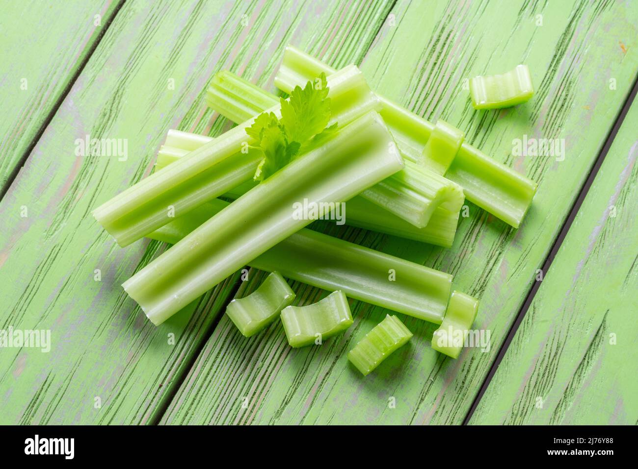 Mucchio di costole di sedano su tavola di legno verde. Sfondo di cibo sano. Foto Stock