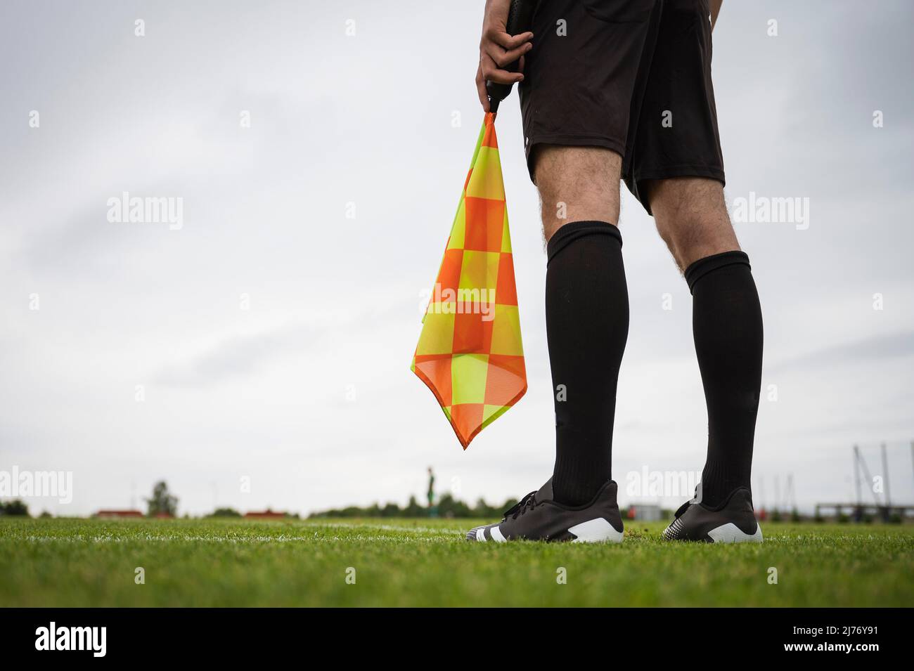 Arbitro calcio linea di contatto - dettaglio delle gambe e della mano con la bandiera. Foto Stock