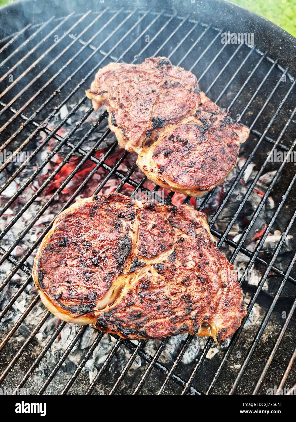 Bistecche di manzo alla griglia sulla griglia a griglia aperta. Foto del processo di cottura della carne o del barbecue. Foto Stock