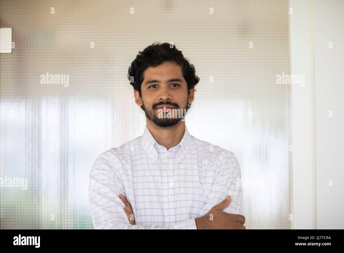 giovane uomo che lavora come manager in un ufficio di fronte a una porta di vetro Foto Stock