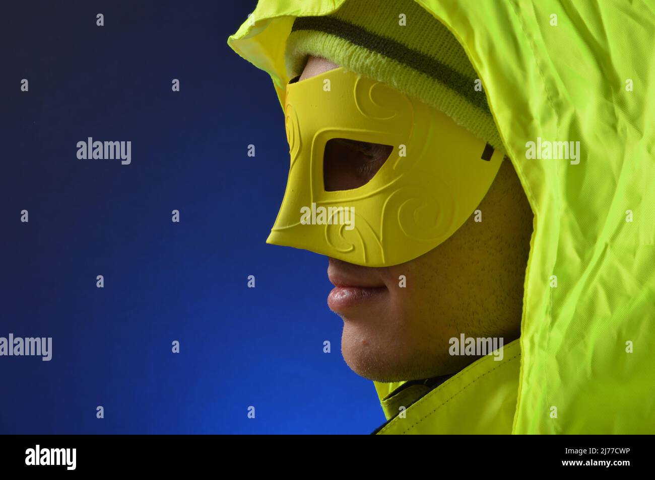Uomo che indossa maschera al neon e vestiti Foto Stock
