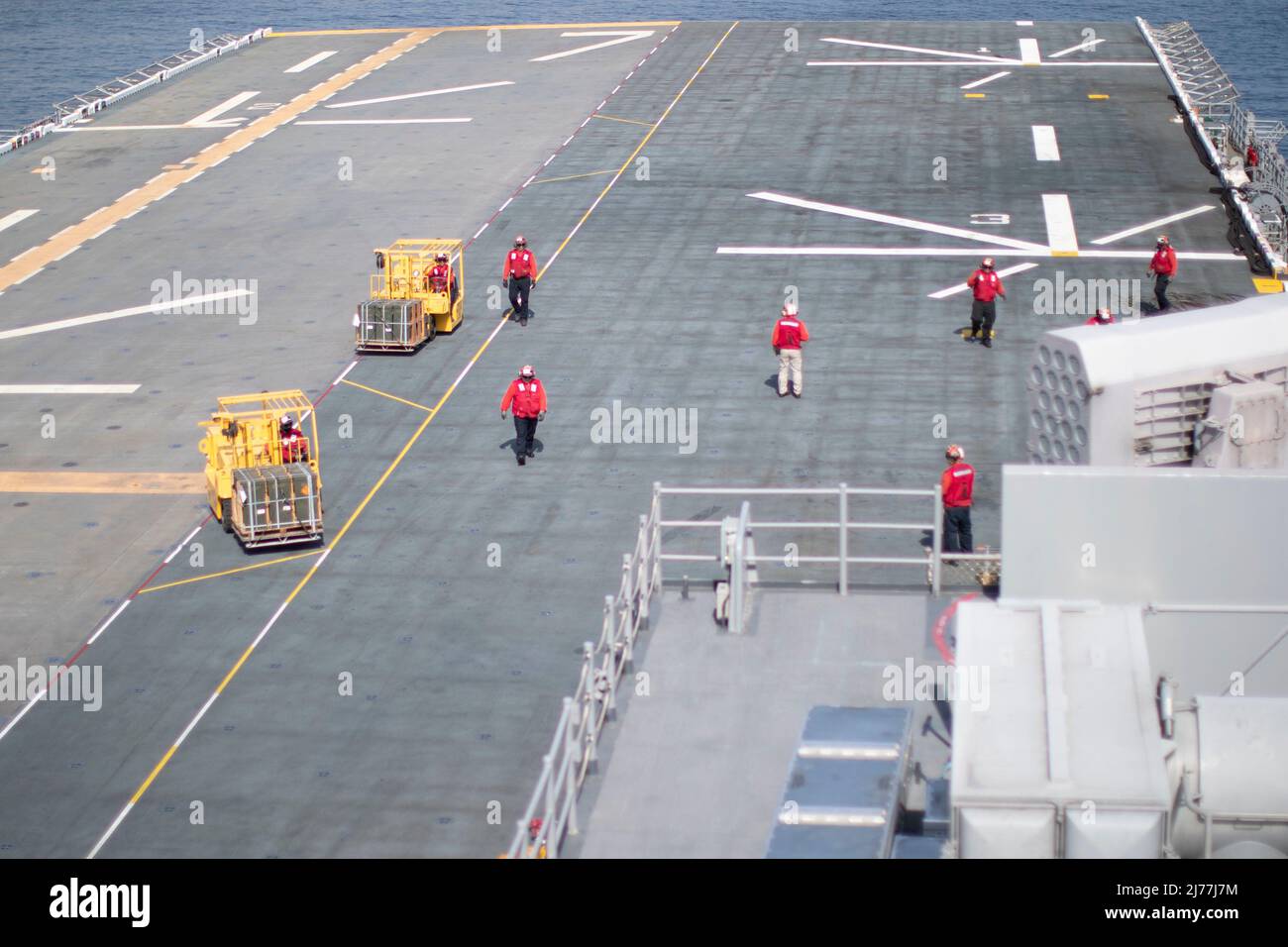 220505-N-CZ759-1097 OCEANO PACIFICO (5 maggio 2022) – i marinai trasportano pallet di munizioni sul ponte di volo a bordo della nave d'assalto anfibio USS Tripoli (LHA 7), 5 maggio 2022. Tripoli sta conducendo operazioni di routine nella flotta USA 3rd. (STATI UNITI Foto Navy di Mass Communication Specialist 2nd Classe Theodore Quintana) Foto Stock