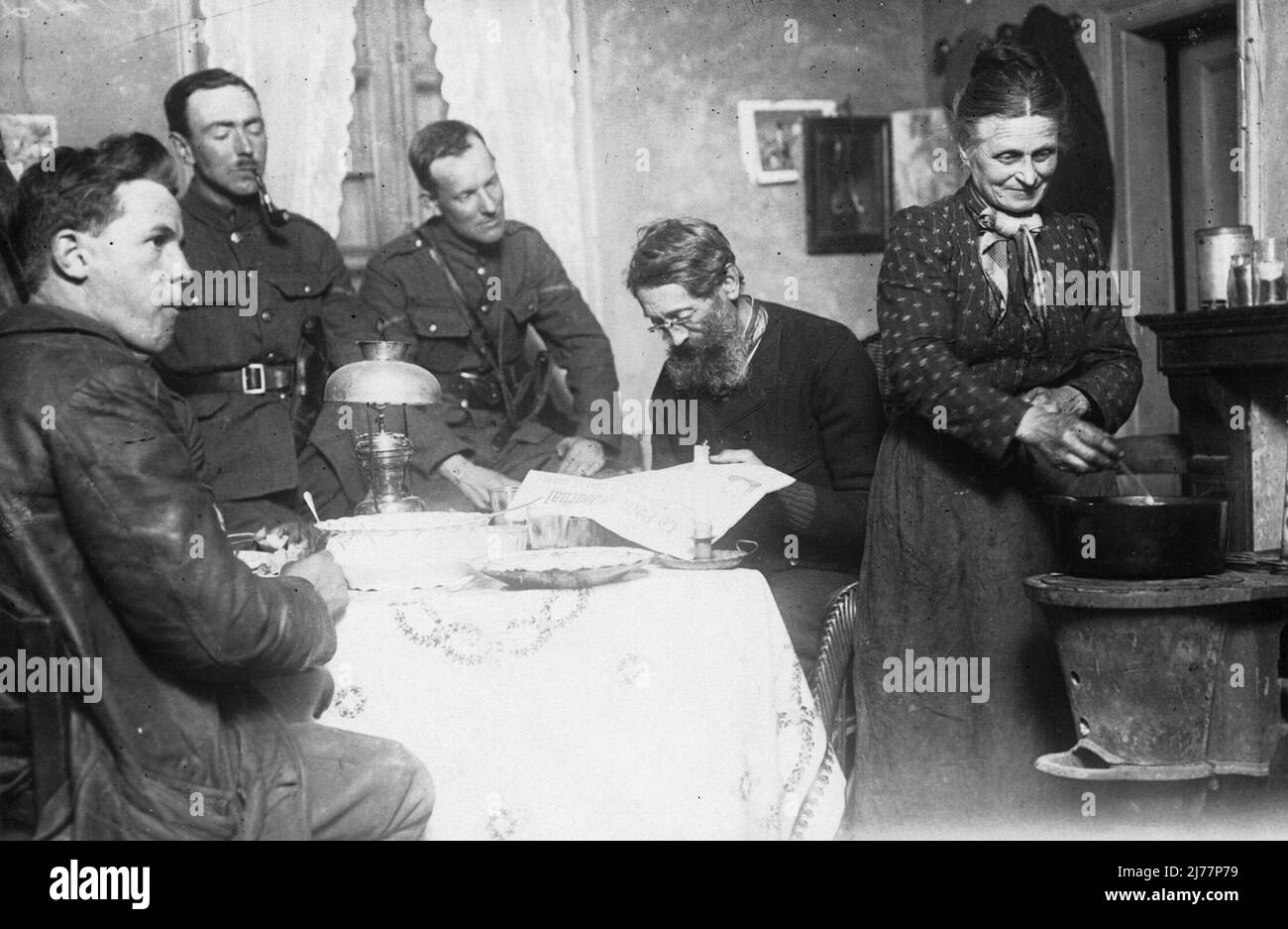 Tre soldati sono seduti attorno ad un tavolo da pranzo in una casa in Francia nel corso del WW1. Una volta che le truppe erano entrate in un villaggio sono state ospitate spesso con le famiglie locali. Foto Stock