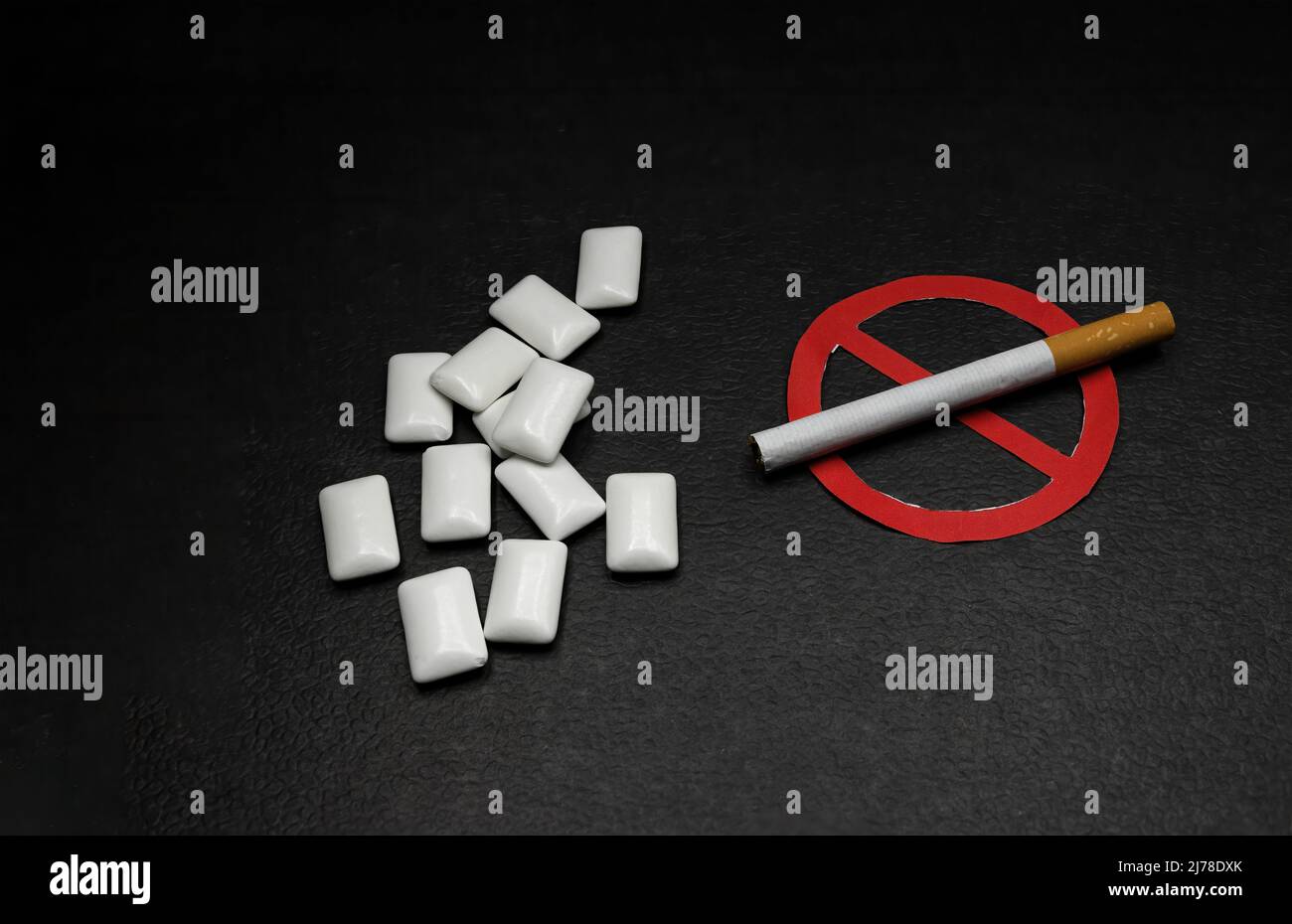 gomma di sostituzione della nicotina accanto ad una sigaretta con il segno proibito, concetto di smettere di fumare Foto Stock