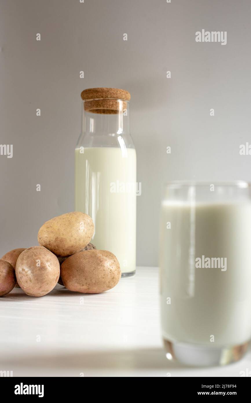 bottiglia di latte di patate su sfondo chiaro Foto Stock