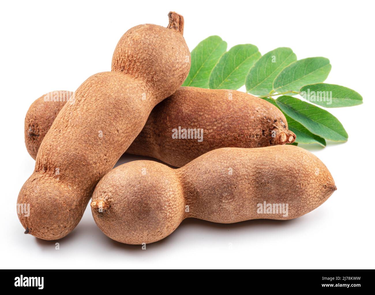 Cialde di frutta e foglie mature di tamarindo isolate su sfondo bianco. Foto Stock