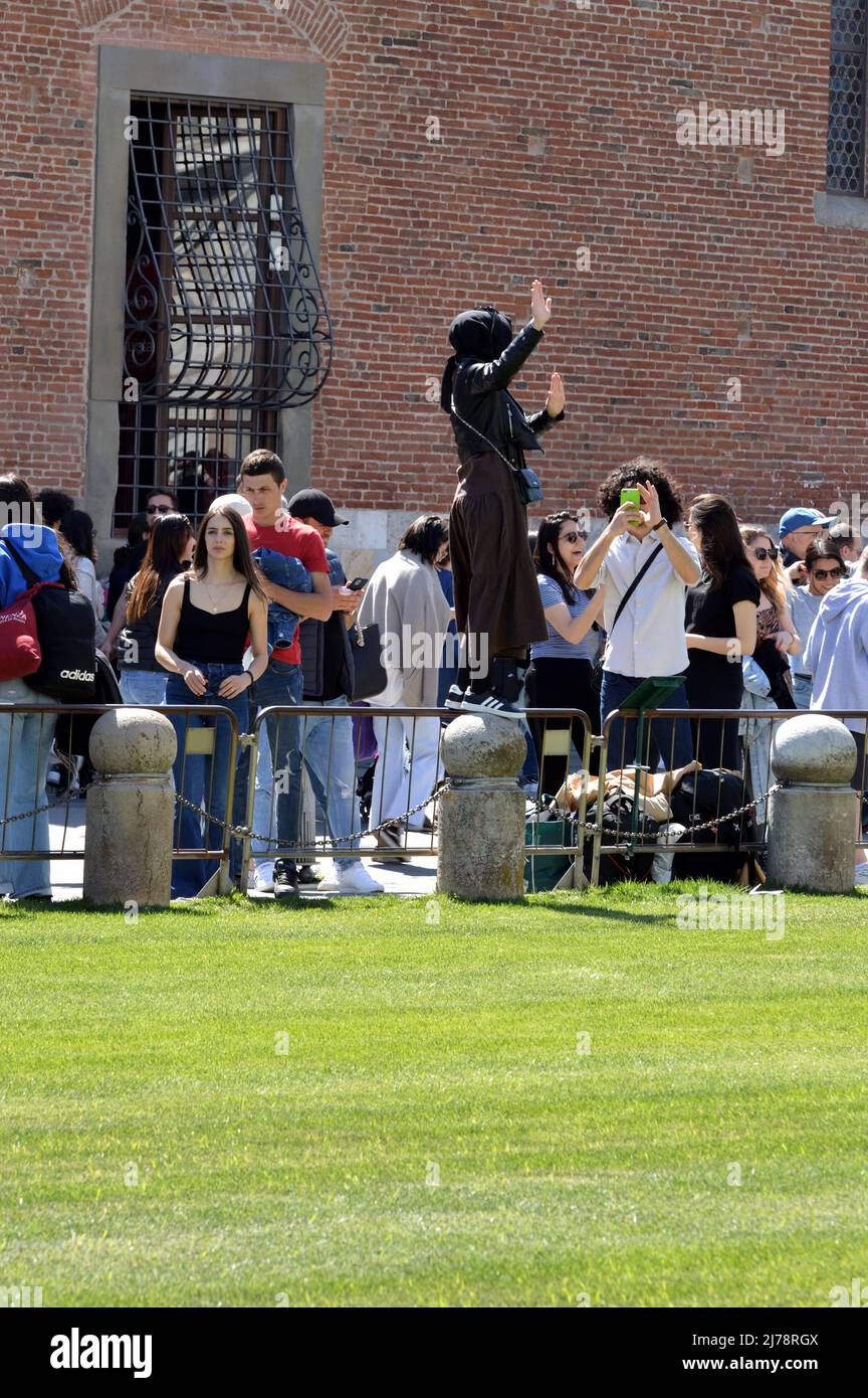 Pisa, Italia - 17 Aprile 2022: Turisti in posa per foto con la torre pendente di pisa Foto Stock