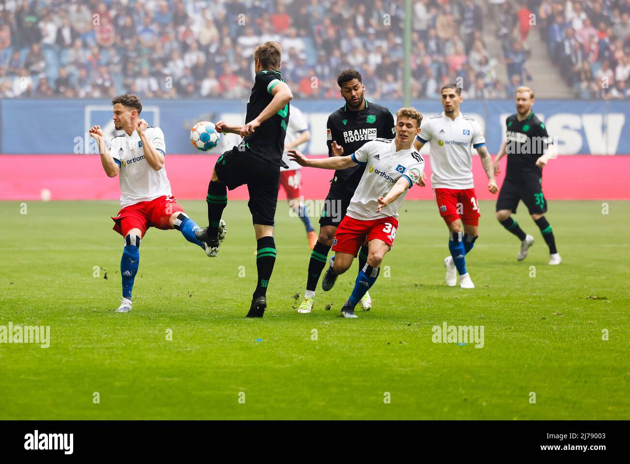 07 maggio 2022, Amburgo: Calcio: 2nd Bundesliga, Hamburger SV - Hannover 96, Matchday 33, Volksparkstadion. Moritz Heyer di Amburgo (l-r), Julian Börner di Hannover, Linton Maina di Hannover e Anssi Suhonen di Amburgo lottano per la palla. Foto: Frank Molter/dpa - NOTA IMPORTANTE: In conformità con i requisiti della DFL Deutsche Fußball Liga e della DFB Deutscher Fußball-Bund, è vietato utilizzare o utilizzare fotografie scattate nello stadio e/o della partita sotto forma di immagini di sequenza e/o serie di foto video-simili. Foto Stock